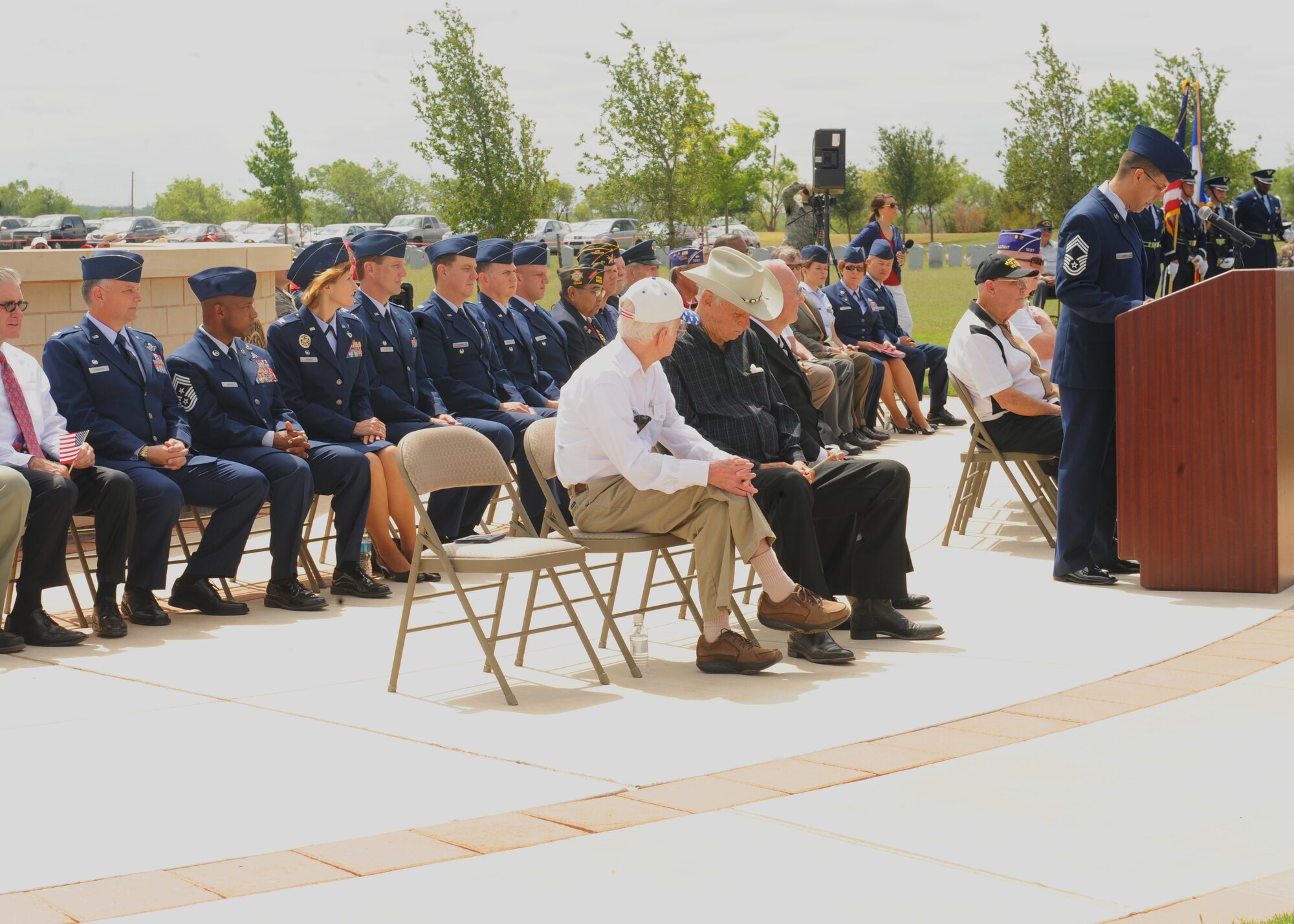 Members from a local motorcycle club stand with American flags during a Memorial Day ceremony held at the Texas State Veterans Cemetery in Abilene, Texas, May 27, 2013. Among the crowd were seven Korean War veterans. A biography was written in honor of each of the veterans. (U.S. Air Force photo by Senior Airman Cierra Presentado/Released)