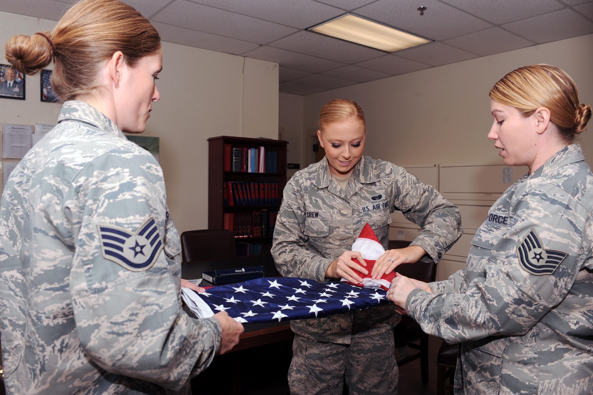U.S. Air Force Airmen from the 355th Fighter Wing Legal Office participated in a flag folding exercise May 21, 2013 as part of the Comprehensive Airman Fitness Week's Scavenger Hunt at Davis-Monthan Air Force Base, Ariz. The week's activities were focused on highlighting safety, resiliency and the social pillar of CAF and started with a wing run, followed by a wingman scavenger hunt where teams of four had to work together to find information and objects related to CAF's social pillar and resiliency. (U.S. Air Force photo by Airman 1st Class Christine Griffiths/Released)