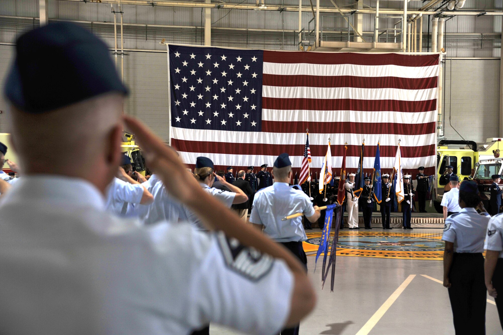 Team Goodfellow members salute as “The Star-Spangled Banner” is played during the 17th Training Wing Change of Command ceremony at the Louis F. Garland Fire Academy high bay, May 29. The ceremony commemorated Col. Mark Damiano relinquishing command of the 17th TRW to Col. Kimberlee Joos. (U.S. Air Force photo/ Senior Airman Michael Smith)