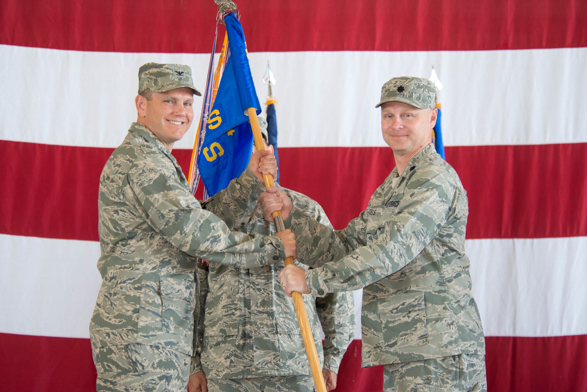 Col. Charles Corcoran, 325th Operations Group commander, passes the 325th Operations Support Squadron guidon to Lt. Col. Clayton Bartels during a change of command ceremony May 23. (U.S. Air Force photo by Lisa Norman)