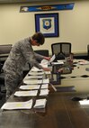 Col. Gretchen M. Wiltse, 512th Mission Support Group commander, organizes notices of proposed furlough May 29, 2013, in preparation for their dissemination to the 250 federal employees assigned to the 512th Airlift Wing, Dover Air Force Base, Del. The memorandum included furlough plans and instructions on submitting responses to the notification within seven days. (U.S. Air Force photo/Master Sgt. Veronica Aceveda)