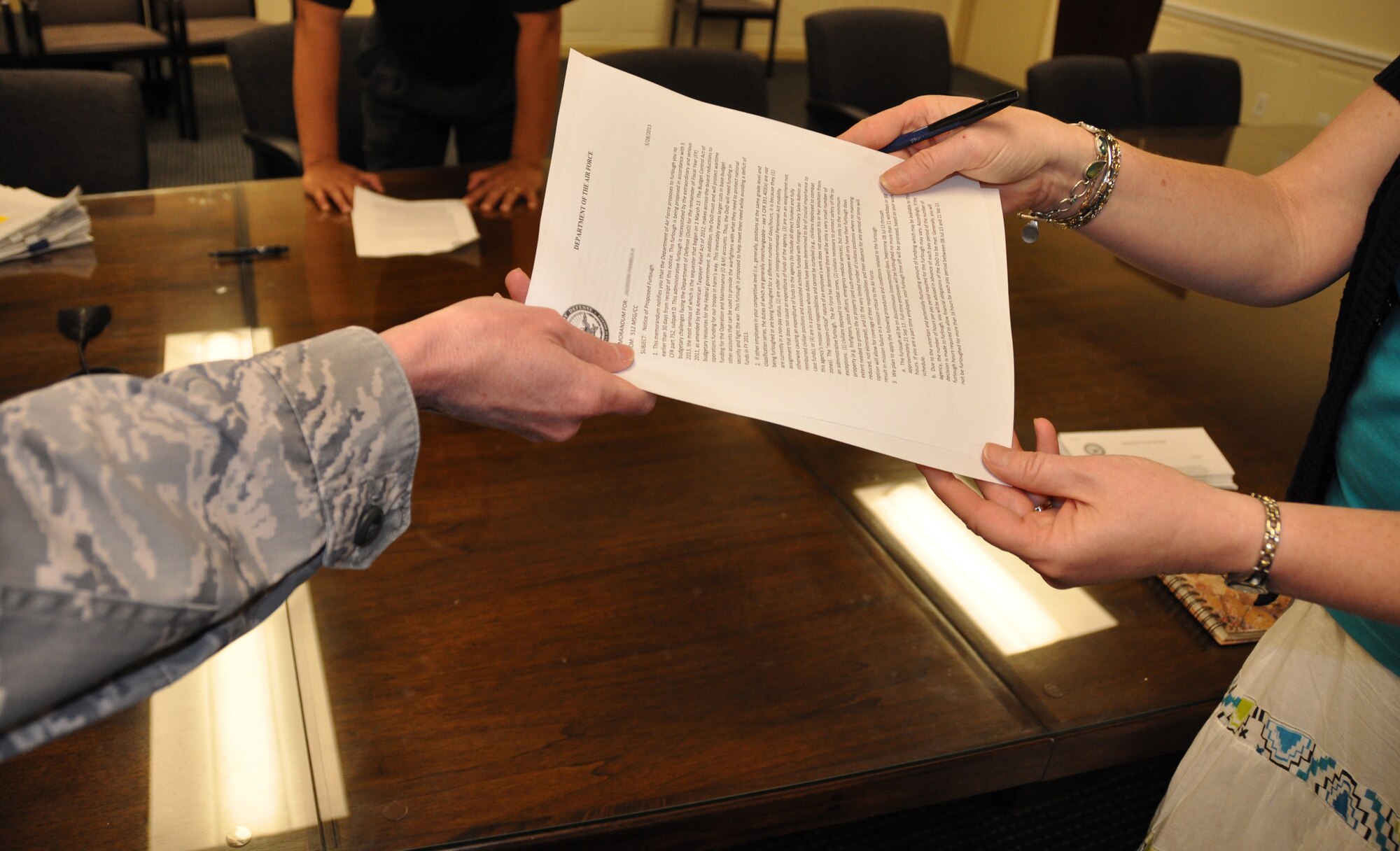 A federal employee assigned to the 512th Airlift Wing, Dover Air Force Base, Del., turns in the notice of proposed furlough she received May 29, 2013. The Reserve wing’s 250 civilian employees received a copy of the memorandum for themselves after signing and returning the original notification to wing leadership. (U.S. Air Force photo/Master Sgt. Veronica Aceveda)   