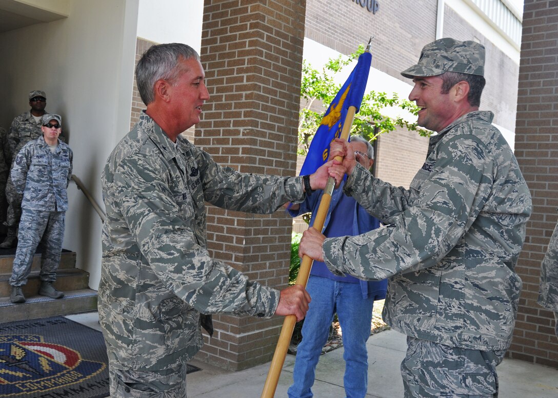 Brig. Gen. Jon Weeks, commander of the Air Force Special Operations Air Warfare Center, left, receives the 6th Special Operations Squadron guidon from Lt. Col. Thomas Geiser, the squadron’s commander, at Duke Field, Fla., May 28, 2013.  Airmen from the 6th SOS delivered the guidon after a symbolic 24.2-mile relay run from their former home at Hurlburt Field, Fla., to their new home at Duke where the active-duty unit will operate as part of the AFSOAWC. (U.S. Air Force photo/Dan Neely)