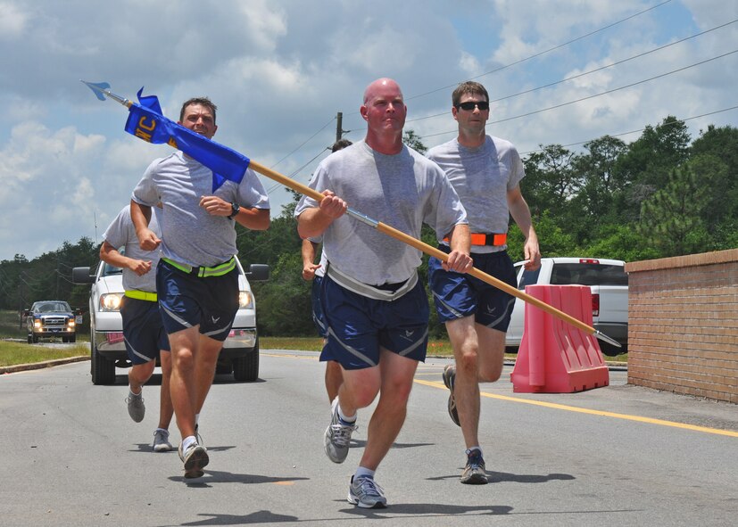 Lt. Col. Joe Michalek, from Headquarters Air Force Special Operations Command, carries the 6th Special Operations Squadron guidon as he and 6th SOS Airmen complete their 2.5-mile leg of a relay run from Hurlburt Field to Duke Field, Fla. May 28, 2013.  The 24.2-mile run symbolized the squadron’s move from its former home to its new Duke Field home where it will operate as part of the Air Force Special Operations Air Warfare Center. (U.S. Air Force photo/Dan Neely)