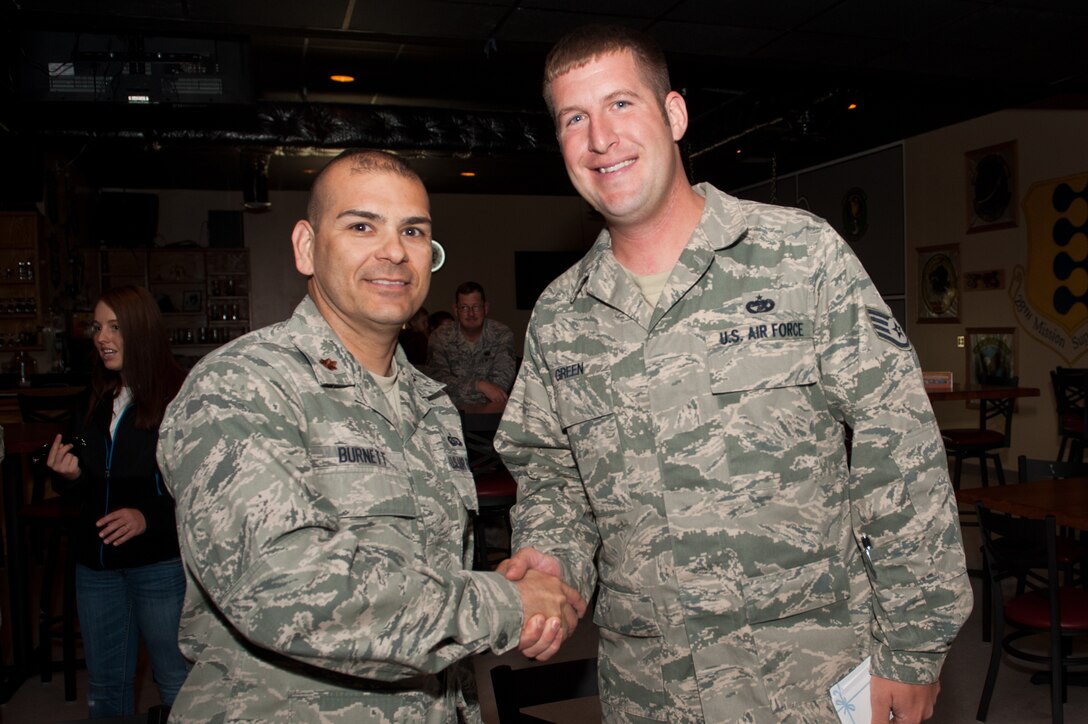 Maj. David Burnett, 28th Force Support Squadron commander, congratulates Staff Sgt. Jacob Green, 28th Logistics Readiness Squadron quality assurance specialist, the winner of the burrito eating contest during the grand opening of V.I.Pete’s Grille and Eddie Pepper’s Mexican Grille in the Dakota’s Club on Ellsworth Air Force Base, S.D., May 21, 2013. Green gulped down his three burritos in under two minutes and claimed the first place prize of $100. (U.S. Air Force photo by Senior Airman Kate Maurer/Released)