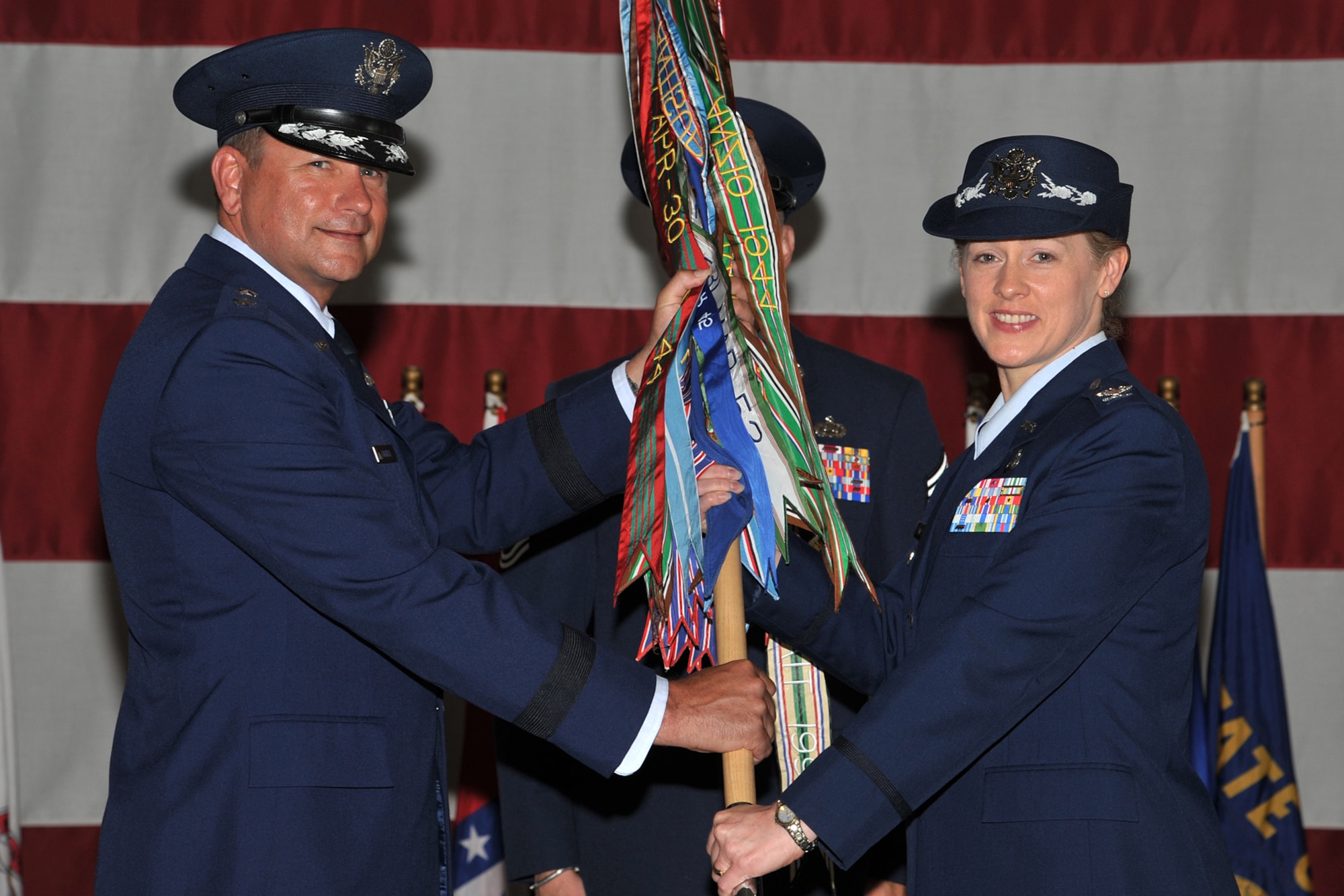 GOODFELLOW AIR FORCE BASE, Texas - Maj. Gen. Leonard Patrick, 2nd Air Force Commander, passes the 17th Training Wing guidon to Col. Kimberlee Joos, 17th TRW incoming Commander, during the Change of Command ceremony at the Louis F. Garland Fire Academy high bay May 29. Col. Joos is the 59th commander of the 17th TRW. (U.S. Air Force photo/ Senior Airman Michael Smith)
