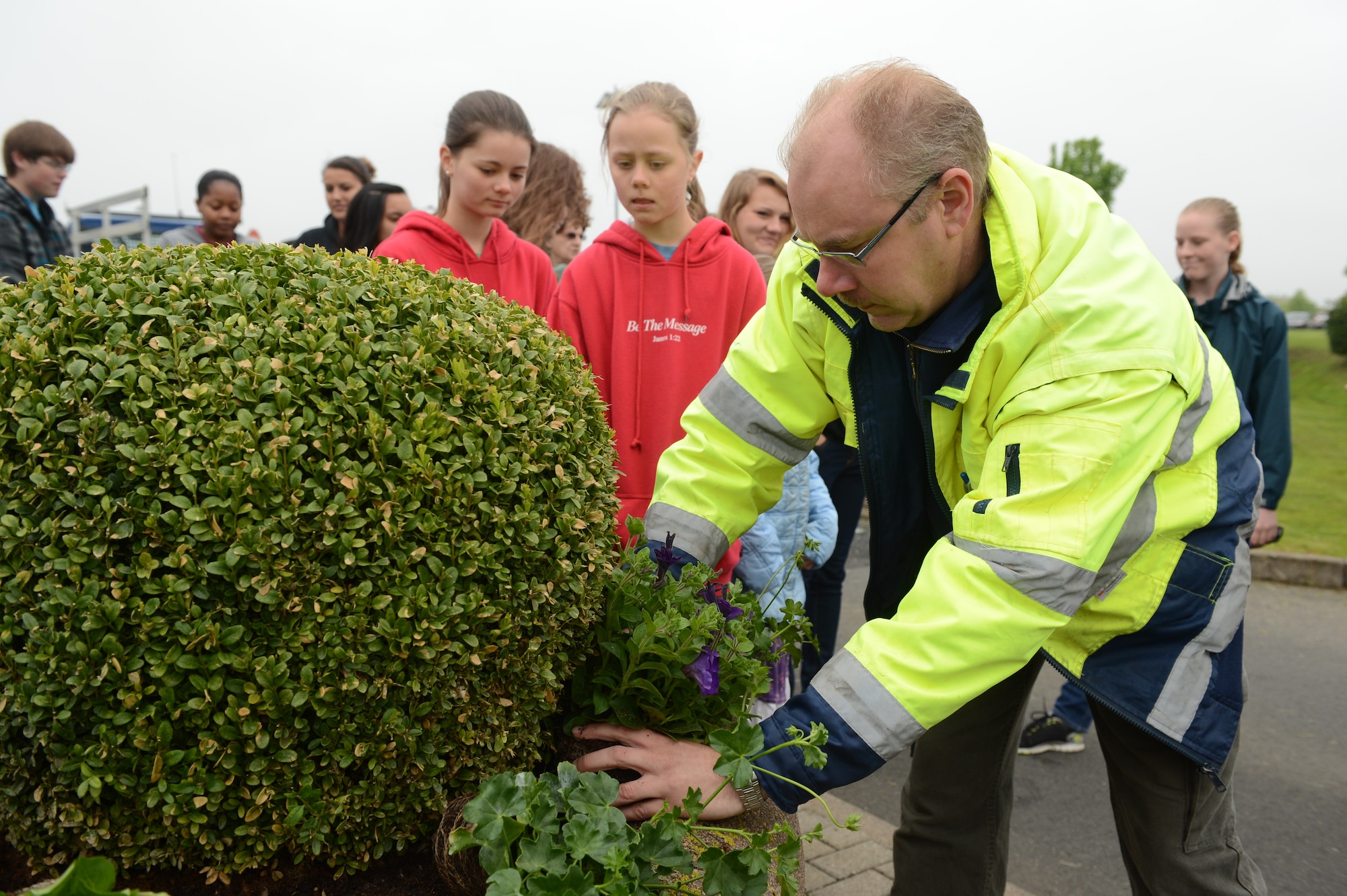 SPANGDAHLEM AIR BASE, Germany -- Henry Krones, material controller from Bitburg, shows volunteers how to plant flowers in Spangdahlem AB planters May 18, 2013. Volunteers planted flowers in an effort to beautify the base. (U.S. Air Force photo by Airman 1st Class Kyle Gese/Released)