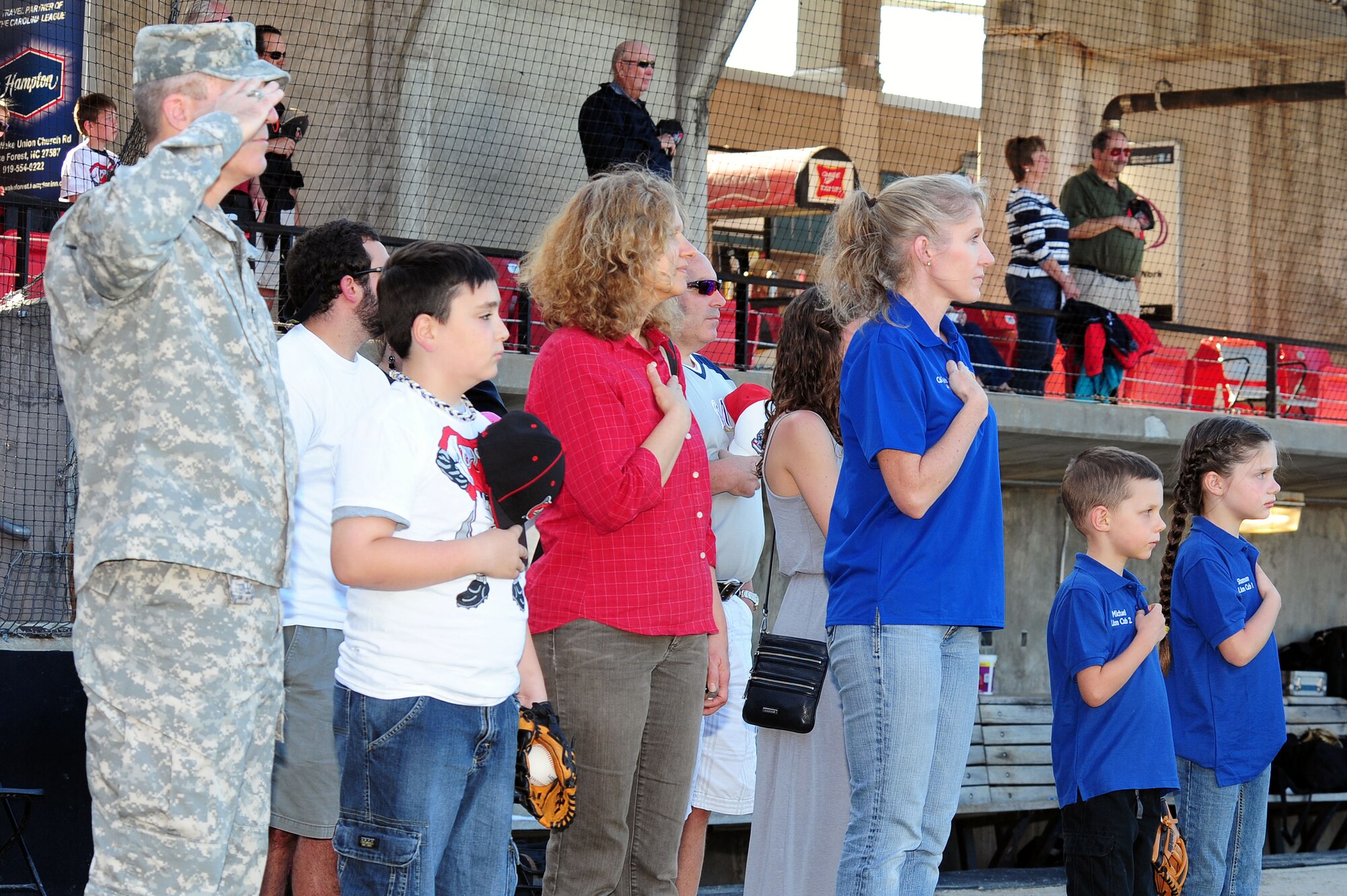 U.S. Air Force Col. Jeannie Leavitt, 4th Fighter Wing commander, along with other honorary guests pay tribute to the national anthem at the Carolina Mudcats stadium in Zebulon, N.C., May 25, 2013. The Mudcats staff gave out free tickets to members of the armed services in honor of Memorial Day. (U.S. Air Force photo by Airman 1st Class John Nieves Camacho/Released)