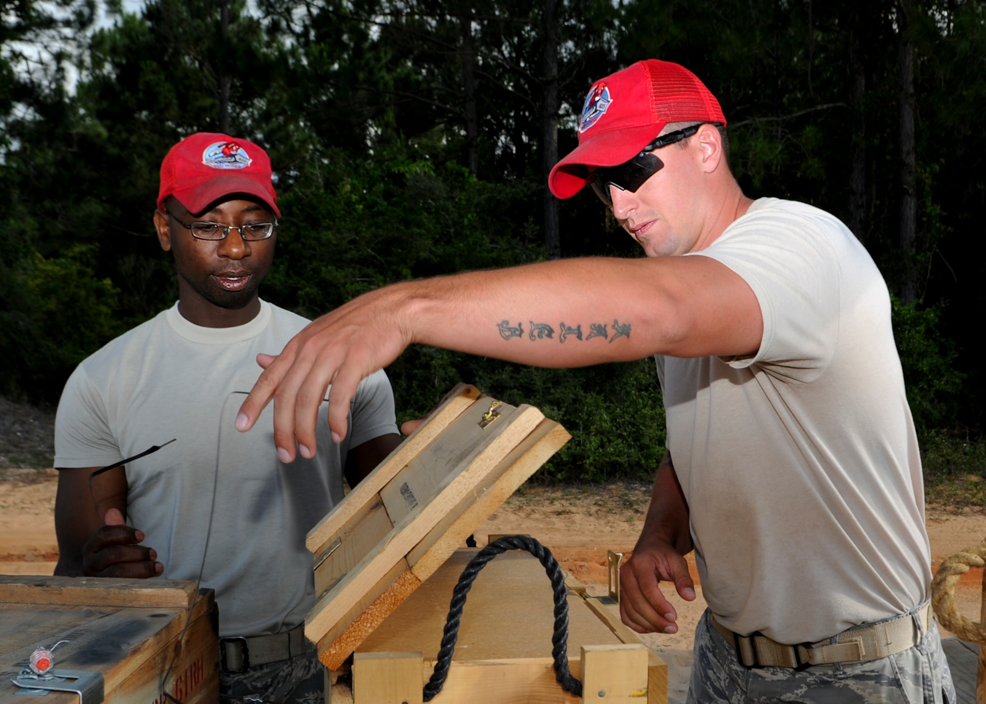 U.S. Air Force Tech. Sgt. Jason Williams and Staff Sgt. Scott Forrest, (right) both demolition team members for 823rd Rapid Engineer Deployable Heavy Operational Repair Squadron Engineers, open a crate of explosives before demolition training on Hurlburt Field, Fla., May 17. 2013. The training ensures the demolition team is fully capable of base denial operations involving destruction of runways, power plants or any infrastructure and civil engineer operations to remove condemned bridges and buildings. (U.S. Air Force photo/Airman 1st Class Christopher Callaway) 
