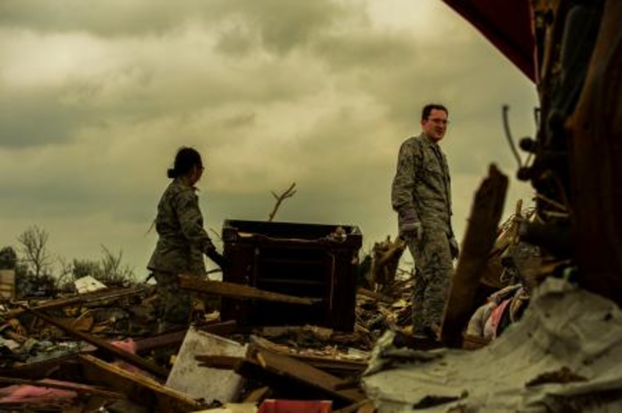 1st Lt. Isaiah Zyduck, right, and 1st Lt. Linna De Cuir search through debris, May 23, 2013, looking for anything salvageable after the devastating tornado, May 20, which damaged more than 13,000 homes in Moore, Okla. More than 600 airmen from the greater Oklahoma area volunteered to assist in the relief efforts. Du Cuir is assigned to the 964th Airborne Air Control Squadron, Tinker Air Force Base, Okla., and hails from Lincolnton N.C. Zyduck is assigned to the 965th AACS, Tinker AFB, and hails from Milwaukee. (U.S. Air Force photo by Staff Sgt. Jonathan Snyder)