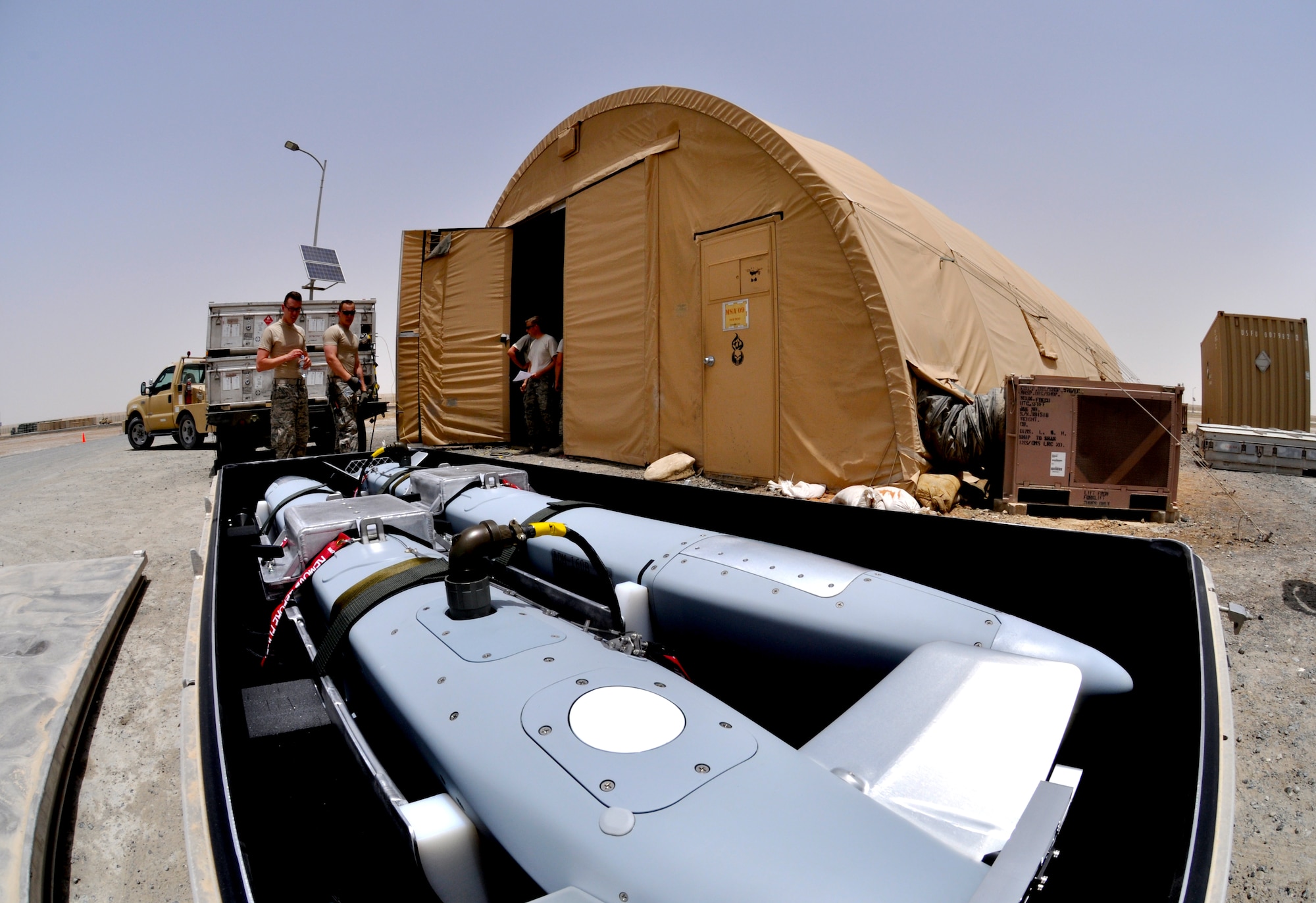 Members of the 380th Expeditionary Maintenance Squadron Ammo Flight prepare two miniature air-launch decoy non-explosive bombs for software updates May 22, 2013, here. Ammo receives, builds, tests and keeps up to date the different munitions that are used here every day. (U.S. Air Force photo by Staff Sgt. Timothy Boyer)