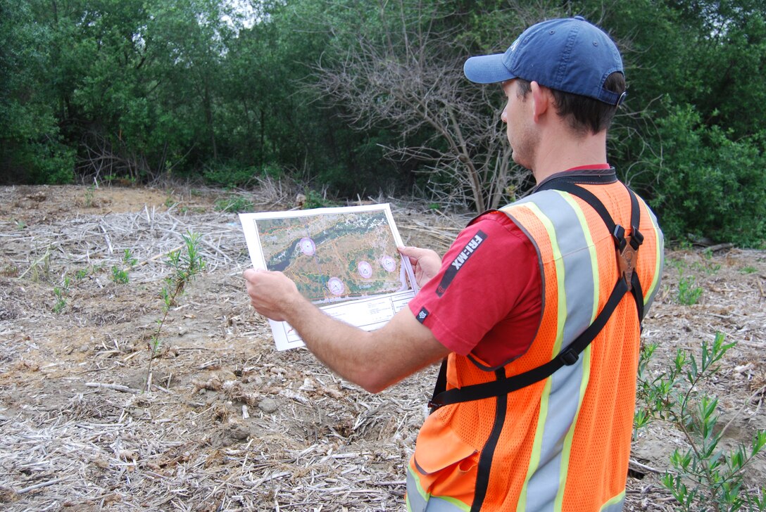 Alex Fromer, a biologist for RECON Environmental, Inc., checks a map on May 17 showing the locations of least Bell's vireo nests along the San Luis Rey River. Crews watering newly-planted native vegetation and spraying exotic plants in the area use the maps to avoid impacts on nesting vireos.