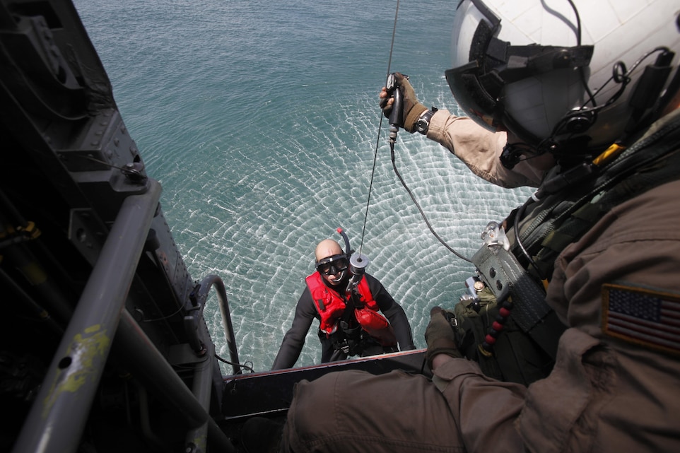 Lance Cpl. Anthony J. DiCola, a crew chief with Marine Transport Squadron 1, hoists Cpl. Kyle A. Alessandro, a rescue swimmer in training, into an HH-46E Sea Knight May 10. A search and rescue team with the squadron saved a boater May 20 who was stranded at sea for three days.