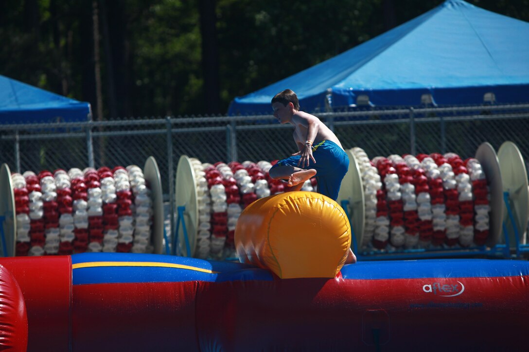 A child jumps over a portion of the inflatable obstacle course at the Hancock Pool May 25.  The obstacle course features barriers, hurdles and a slide that ends with a splash in the pool.