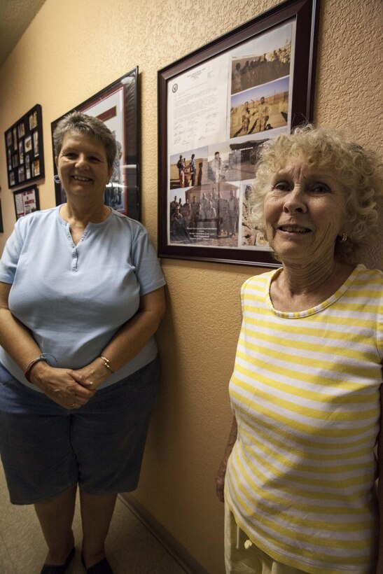 Left: Debi Mustain, the Coyote Ranch assistant troop committee coordinator and a native of Yuma, Ariz., and Peggy Munger, the Coyote Ranch troop committee coordinator and a native of Yuma, Ariz., proudly display some of the photos of deployed Marines at Coyote Ranch Yuma, Ariz., May 20.