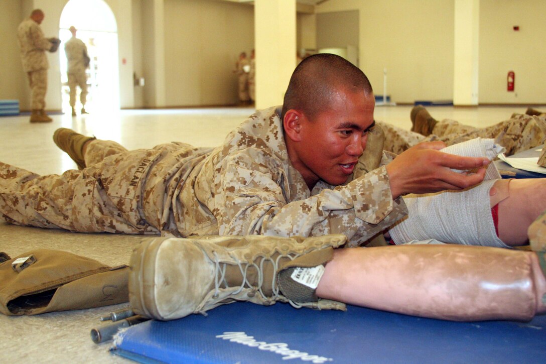 A recruit from Company A, 1st Recruit Training Battalion, demonstrates proficiency in combat first aid during the practical application test aboard Marine Corps Recruit Depot San Diego May 21. Recruits must perform proper first aid techniques with confidence on a simulated casualty in order to pass this portion of the test. (U.S. Marine Corps photo by Lance Cpl. Pedro Cardenas/ Released)