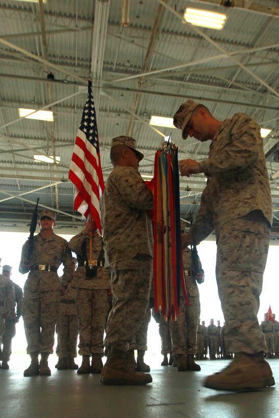 Sergeant Major Jimmy Sanchez, the sergeant major for Marine Fighter Attack Squadron 312, holds VMFA-312's colors while Lt. Col. Joseph Reedy, the commanding officer of VMFA-312, places battle streamers on the colors during a rededication to colors ceremony aboard Marine Corps Air Station Beaufort, May 23. The rededication to colors ceremony marked VMFA-312's 70th anniversary. VMFA-312 was commissioned on June 1, 1943 at Page Field aboard Marine Corps Recruit Depot Parris Island.