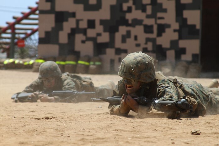 Recruits of Company M, 3rd Recruit Training Battalion, perform a low crawl with their M16-A4 service rifles during the Crucible confidence course at Edson Range aboard Marine Corps Base Camp Pendleton, Calif. May 21.  The Crucible is designed to simulate real life combat situations that recruits must go through with minimal food and sleep.  (U.S. Marine Corps photo by Lance Cpl. Benjamin E. Woodle/Released)