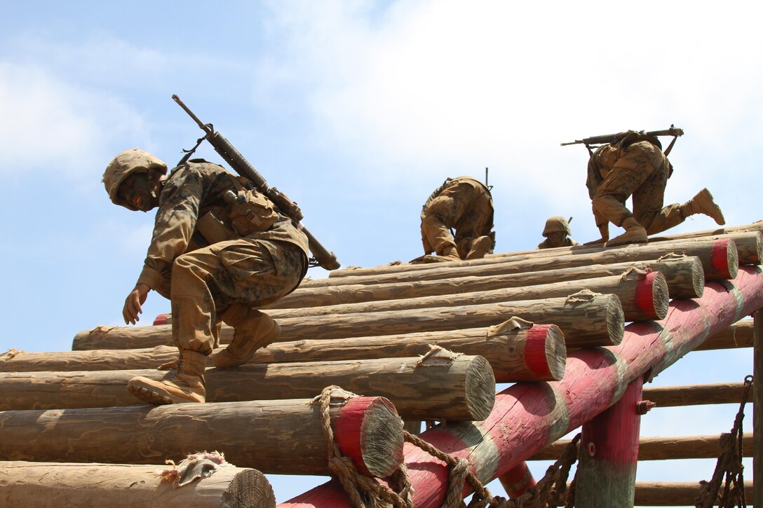 Recruits of Company M, 3rd Recruit Training Battalion, navigate through an elevated log obstacle during the Crucible confidence course at Edson Range aboard Marine Corps Base Camp Pendleton, Calif. May 21.  The series of obstacles are designed to help recruits conquer their fears and develop teamwork.  (U.S. Marine Corps photo by Lance Cpl. Benjamin E. Woodle/Released)