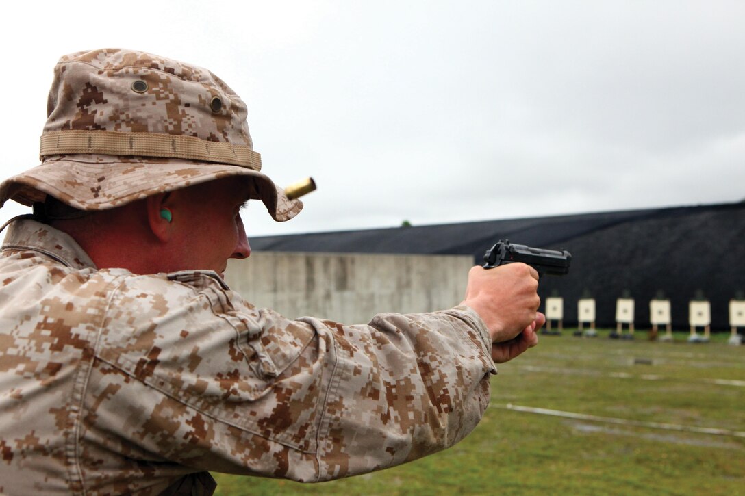 Staff Sgt. Casey Wojtkowski fires an M9 service pistol May 21 during a pistol qualification course of fire at Camp Hansen. "This was my first time shooting the pistol, and I have high expectations of shooting expert," said Wojtkowski, a landing support specialist with 3rd Marine Logistics Group, III Marine Expeditionary Force. (Photo by Lance Cpl. Jose D. Lujano)