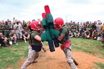 Lance Cpl. Kierston T. Broussard, left, and Pfc. Marcel O. Murray, compete in a pugil-stick bout May 24 during the 3rd Marine Logistics Group 55th anniversary celebration at Camp Kinser. "The celebration provides the opportunity to unite each regiment and battalion of 3rd MLG and rejoice in the exemplary performance of the group," said Brig. Gen. Niel E. Nelson, the commanding general of 3rd MLG, III Marine Expeditionary Force. Broussard is a radio repairman with 3rd Maintenance Battalion, 3rd MLG. Murray is a warehouse clerk with 3rd Supply Battalion, 3rd MLG.