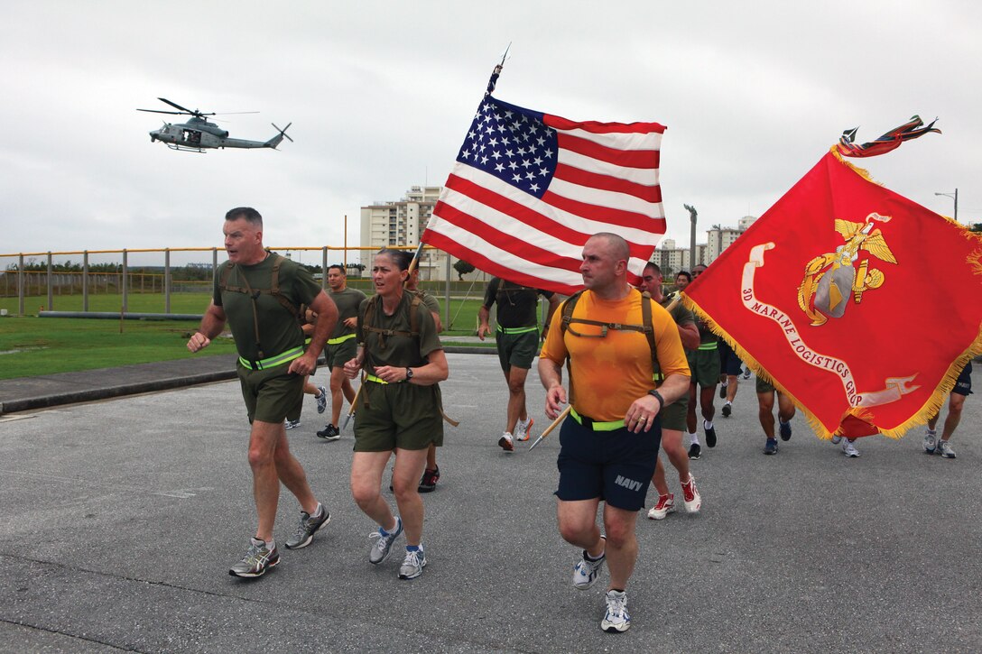 Brig. Gen. Niel E. Nelson, left, Sgt. Maj. Tamara L. Fode, center, and Master Chief Petty Officer Donald C. Schrader, lead a unit run May 24 during the 3rd Marine Logistics Group 55th anniversary celebration at Camp Kinser. "3rd MLG has just finished a very successful and operationally packed year," said Nelson, the commanding general of 3rd MLG, III Marine Expeditionary Force. Fode is the 3rd MLG sergeant major, and Anderson is the 3rd MLG command master chief.