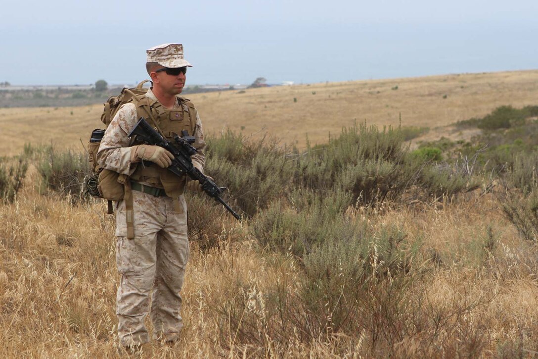 First Lt. Michael Cooley, a platoon commander serving with Mobility Assault Company, 1st Combat Engineer Battalion, scans the area for footprints and other evidence of recent human movement through the area during a combat tracking course offered by the Tactical Tracking Operations School here, May 16, 2013. Cooley, a native of Algonquin, Ill., is an Eagle Scout and has been involved with Scouting for nearly 20 years. While 1st CEB is training to deploy to Afghanistan during the fall, Cooley devotes much of his free time to Scouting. Growing up Cooley's father was his den leader, now Cooley is a den leader for his son, Isaac.