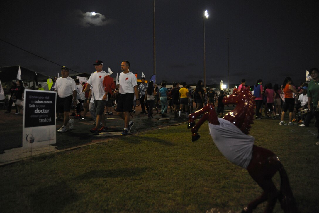 Staff Sgt. Ryan Cassell (left) and Senior Master Sgt. Jason Baker,  both 554th RED HORSE Squadron, walk a lap during the Relay For Life event at George Washington High School, Mangilao, Guam, May 24, 2013. More than 500 people from Andersen Air Force Base and the local community participated in this year’s relay, raising $441,329.97 to help find a cure for cancer. (U.S. Air Force photo by Senior Airman Robert Hicks/Released)
