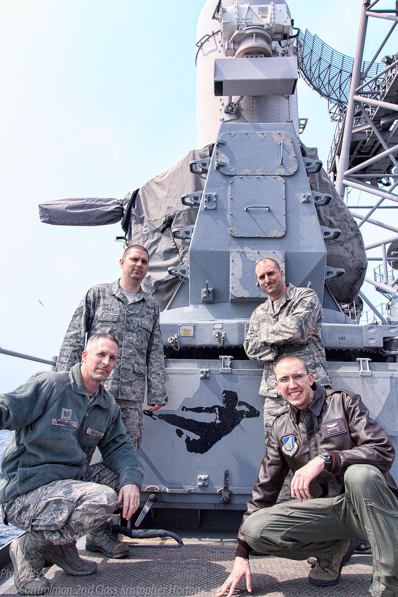 From left: U.S Air Force Tech. Sgt. Kenneth Warren, Staff Sgt. Devon Sonley, Tech. Sgt. Daniel Roshio, and 1st Lt. Preston Phillips, all assigned to the 35th Fighter Wing, pose in front of a weapons system nicknamed 'Bruce Lee' aboard the U.S. Navy’s USS Shiloh, May 10, 2013. The visit was part of a joint-training exercise between the U.S. Navy and U.S. Air Force that controlled F-16 Fighting Falcons through various scenarios over the Pacific Ocean and mainland Japan. (U.S. Navy courtesy photo)