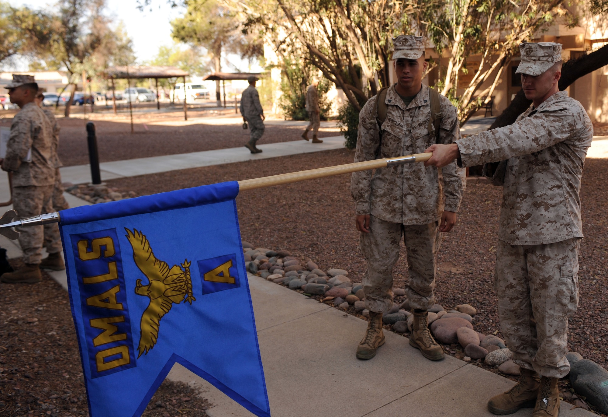 U.S. Marine Corps Sgt. Timothy Taylor, Corporals Leadership Course instructor from Bulk Fuel Company C, 6th Engineer Support Battalion, 4th Marine Logistics Group at Luke Air Force Base, Ariz., instructs a student on a proper guidon technique at Davis-Monthan AFB, Ariz., May 19, 2013. The two-week course is designed to equip new, or soon-to-be, noncommissioned officers with the tools and knowledge to effectively lead their troops, no matter the service.  (U.S. Air Force photo by Senior Airman Timothy Moore/Released)