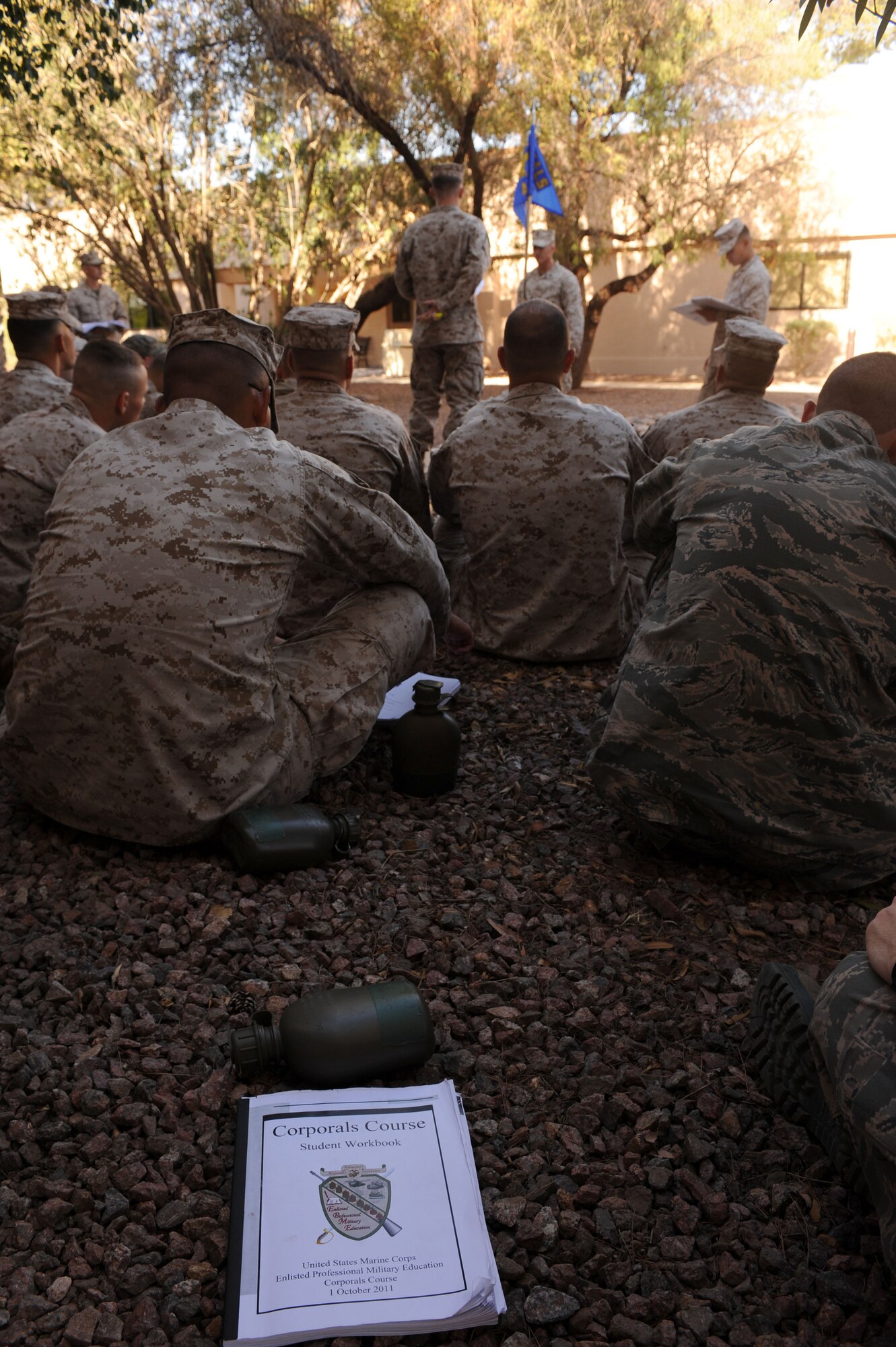 A U.S. Marine Corps Corporals Leadership Course student workbook lies on the ground as students are being instructed on proper guidon techniques at Davis-Monthan Air Force Base, Ariz., May 19, 2013. For two weeks, service members from three U.S. military branches worked, learned and trained together.  (U.S. Air Force photo by Senior Airman Timothy Moore/Released)