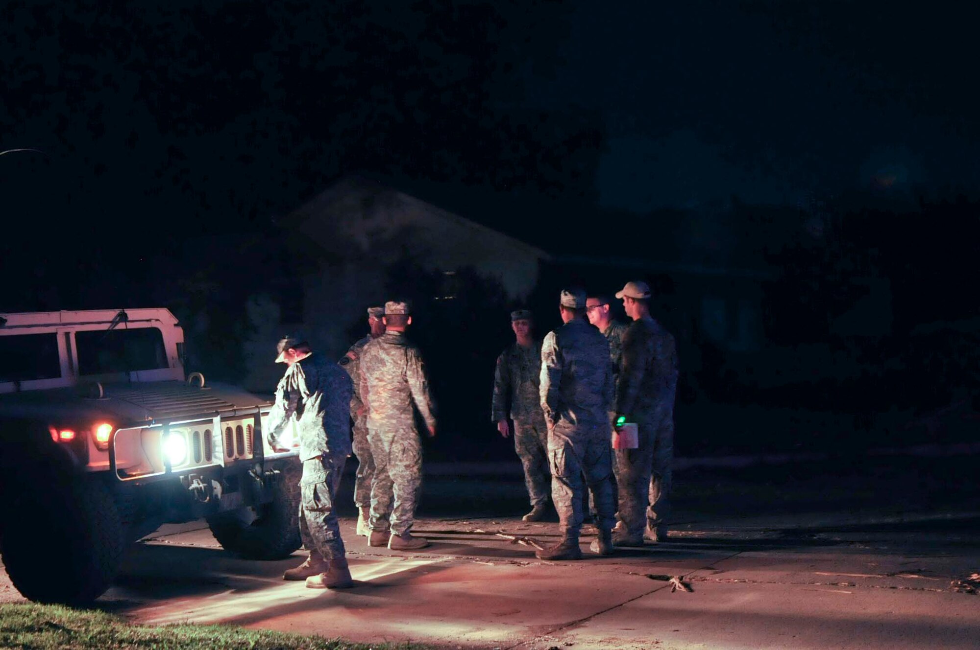 Oklahoma Army Guard and Air National Guard members conduct a shift change at a checkpoint during the night in Moore, Okla., May 22, 2013. Joint military rescue, relief and security assets were deployed by Oklahoma's Governor, Mary Fallin, after the devastating tornado that struck May 20, 2013. (U.S. Air Force photo/Staff Sgt. Caroline Hayworth)