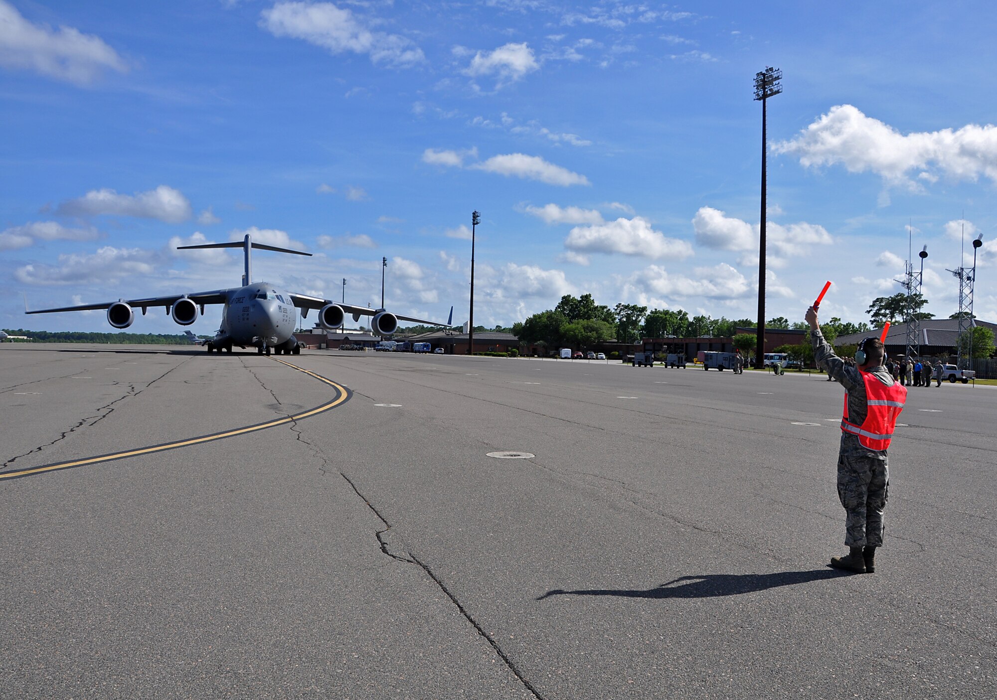 A Joint Base Charleston maintenance Airman marshalls the 22nd C-17 Globemaster III in the Air Air Force inventory and the second to last in the Air Force C-17 program to leaving the Boeing plant in Long Beach, Calif. after the jet landed at Joint Base Charleston, S.C. after  May 30. (U.S. Air Force Reserve Photo by Michael Dukes)