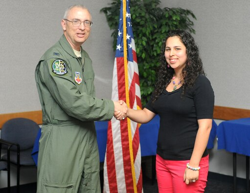 Col. Brian, 9th Aerospace Medical and Dental Squadron commander, presents Laura Kinne a coin for completing Heart Link at the Airman and Family Readiness Center on Beale Air Force Base Calif., May 30, 2013. Heart Link is an opportunity for commanders’ spouses to meet and mentor new spouses to the base. (U.S. Air Force photo by Airman 1st Class Bobby Cummings/Released)