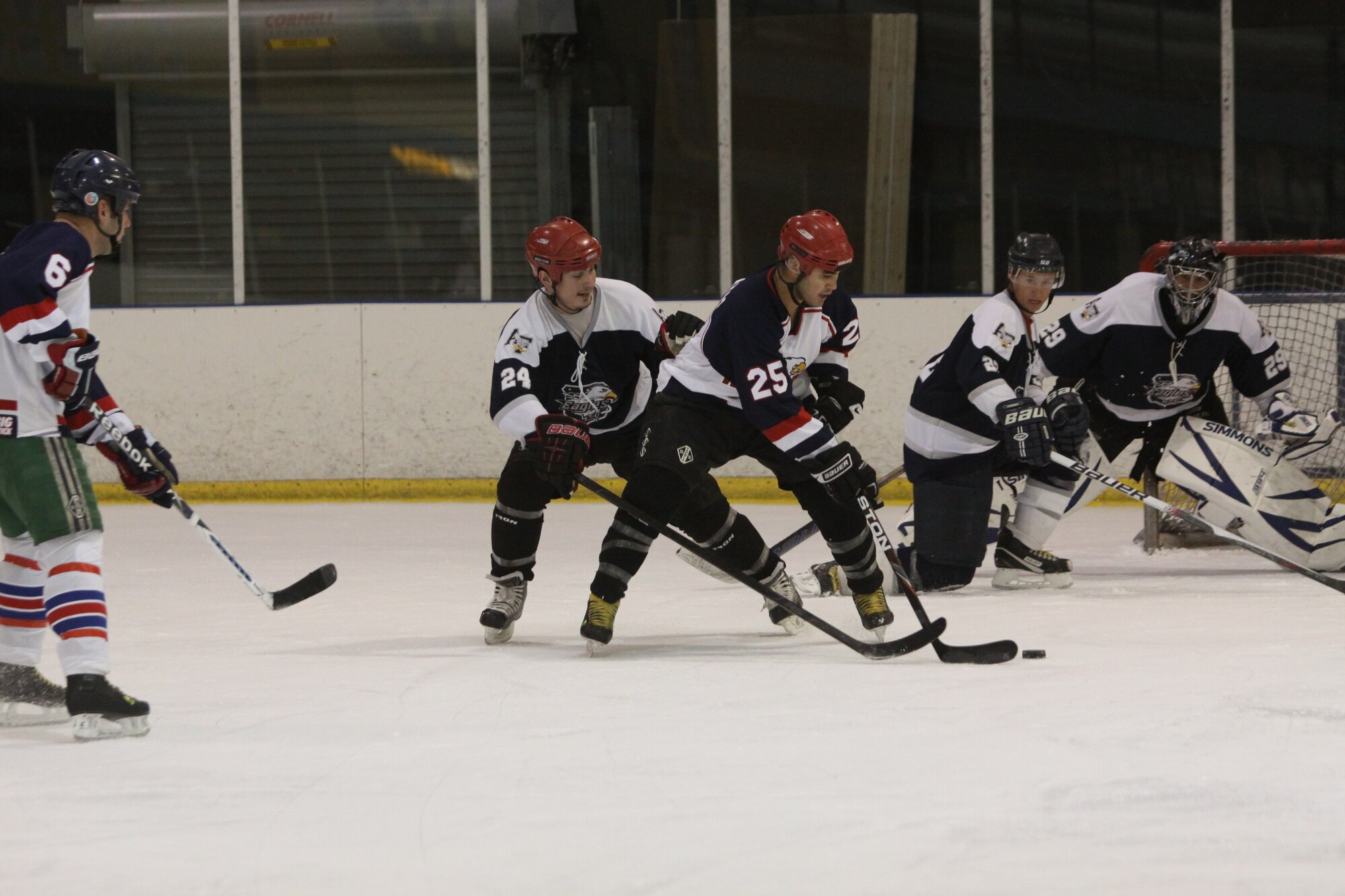 2nd Lt. Jonathon Fong, No. 25 of the Kirtland Warbirds, attempts to move the puck around a defender. Fong works in the Space Development Test office. (Courtesy photo)