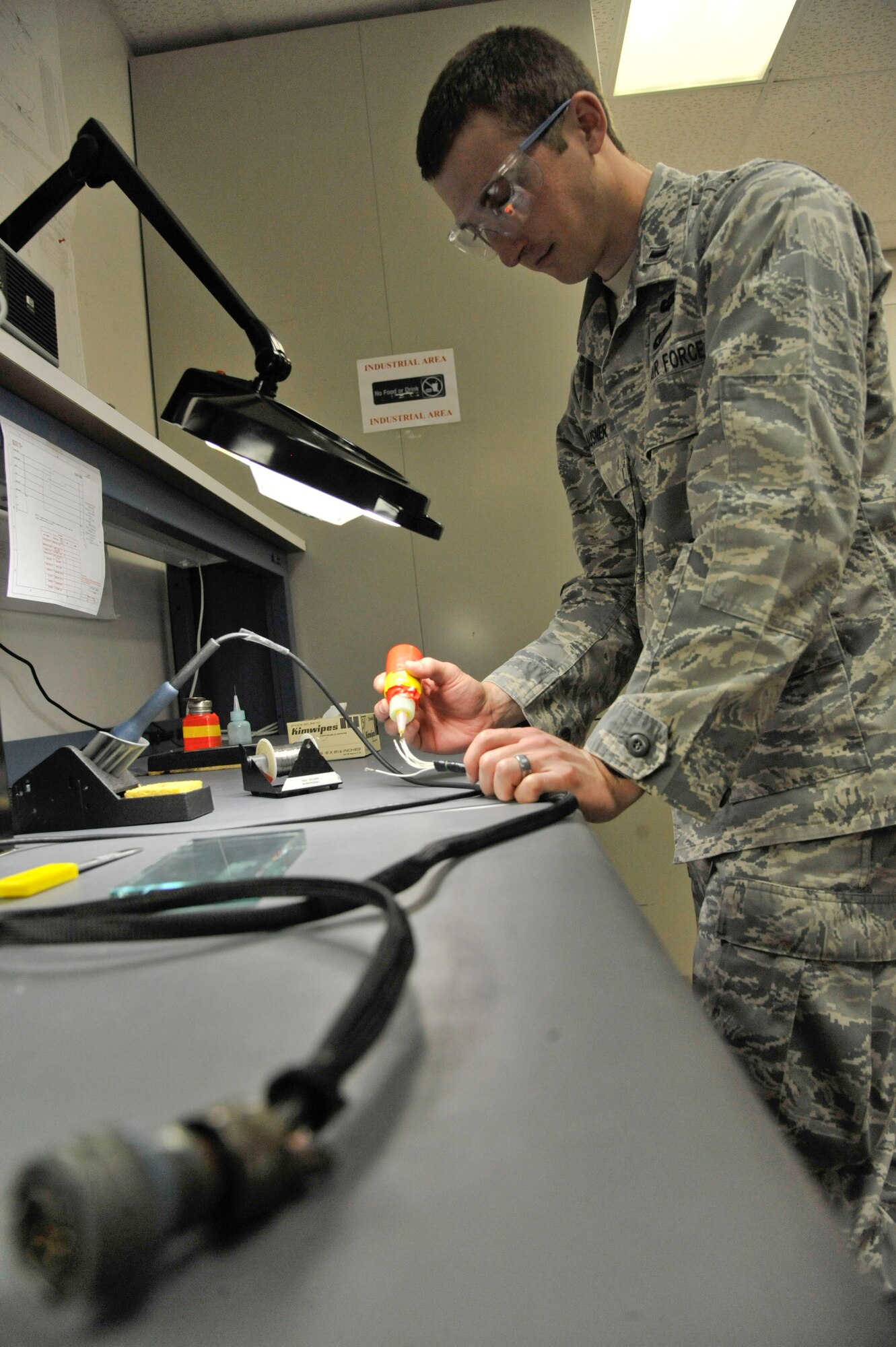 1st Lt. Andrew Klausner, 509th Maintenance Operations Squadron flight commander, solders wiring for the adaptable communications suite keyboard at Whiteman Air Force Base, Mo., May 15, 2013. Soldering makes wires more rigid, preventing them from crimping and presenting a maintenance problem. (U.S. Air Force photo by Airman 1st Class Keenan Berry/Released)