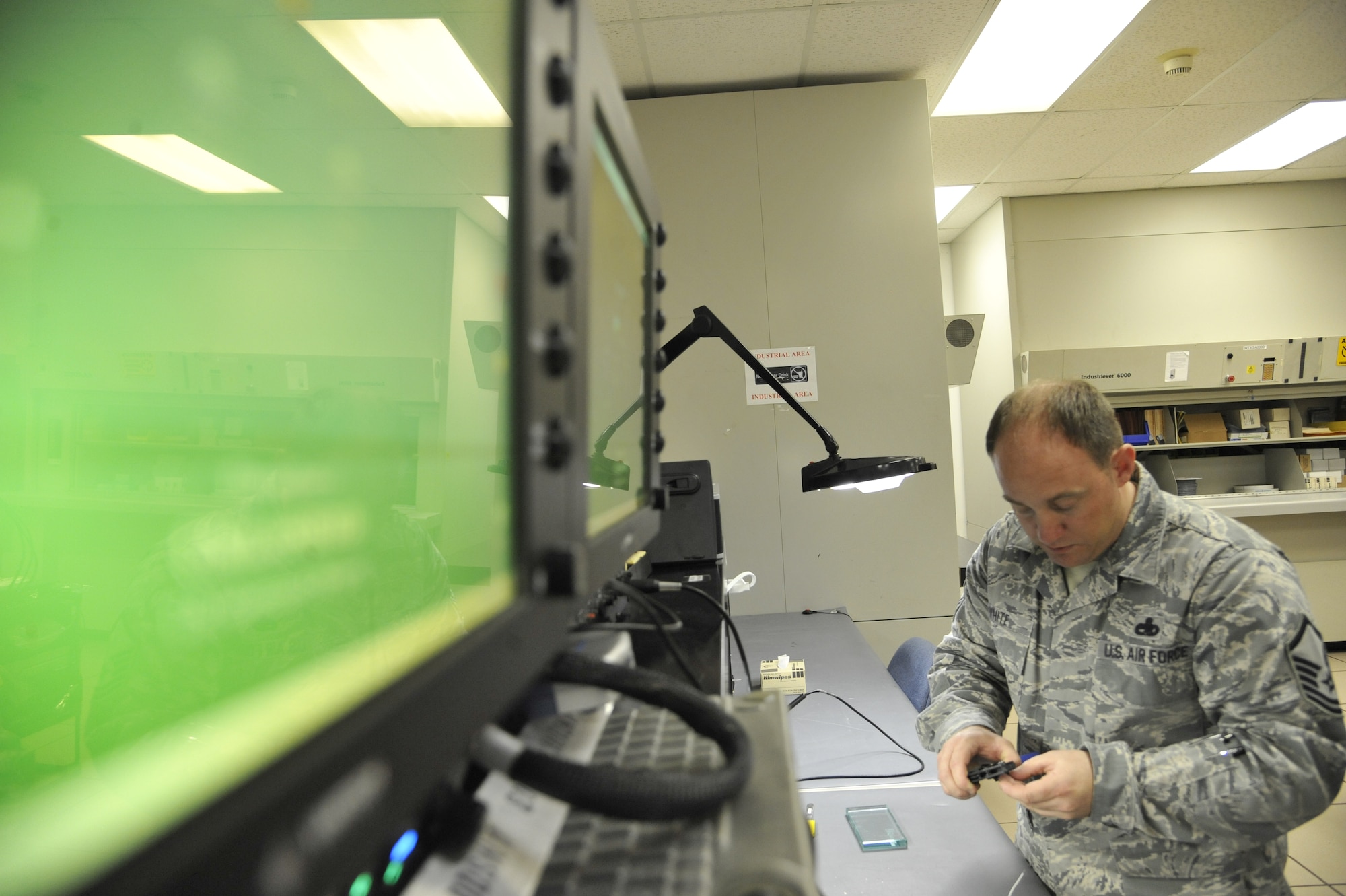 Master Sgt. Michael White, 509th Maintenance Operations Squadron B-2 Spirit computer-aided design manager, crimps a pin on the adaptable communications suite keyboard at Whiteman Air Force Base, Mo., May 15, 2013. Research engineers provide repairs for ACS keyboards by making the wires more durable. (U.S. Air Force photo by Airman 1st Class Keenan Berry/Released)
