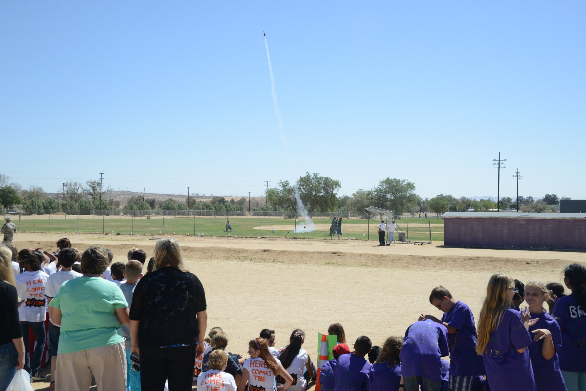 Onlookers watch a rocket soar into the "stratosphere" during the 1st Annual
Edwards Intermediate Space Challenge held at Branch Elementary.  Twelve
teams competed for six awards including "Highest Altitude." (U.S. Air Force
photo by Kenji Thuloweit)
