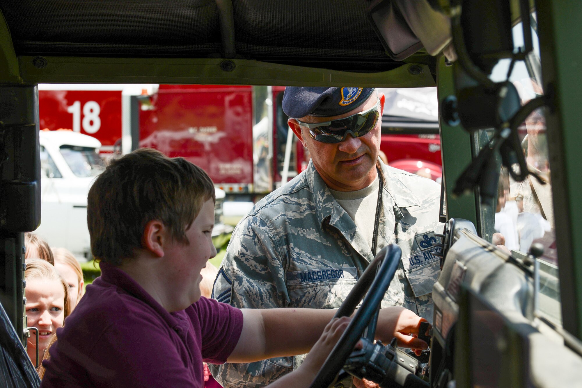 U.S. Air National Guard Master Sgt. Joseph MacGregor, 165th Airlift Wing Security Forces Squadron, shows a student the interior of a HUMVEE vehicle, May 10, 2013 at Sand Hill Elementary in Guyton, Ga. MacGregor answered questions about Air Force Law Enforcement during the annual transportation/career day.(U.S. Air National Guard photo by Tech. Sgt. Charles Delano/Released)