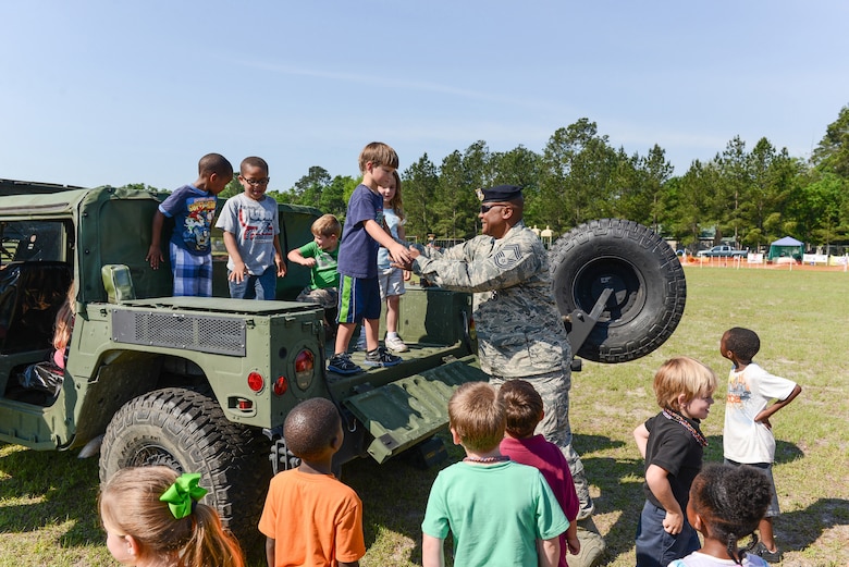 U.S. Air National Guard Chief Master Sgt. Nathanial Brownlee, 165th Airlift Wing Security Forces Squadron, explains the purpose of the Humvee vehicle to students, May 10, 2013 at Sand Hill Elementary in Guyton, Ga. Brownlee answered questions about Air Force Law Enforcement during the annual transportation/career day. (U.S. Air National Guard photo by Tech. Sgt. Charles Delano/Released)