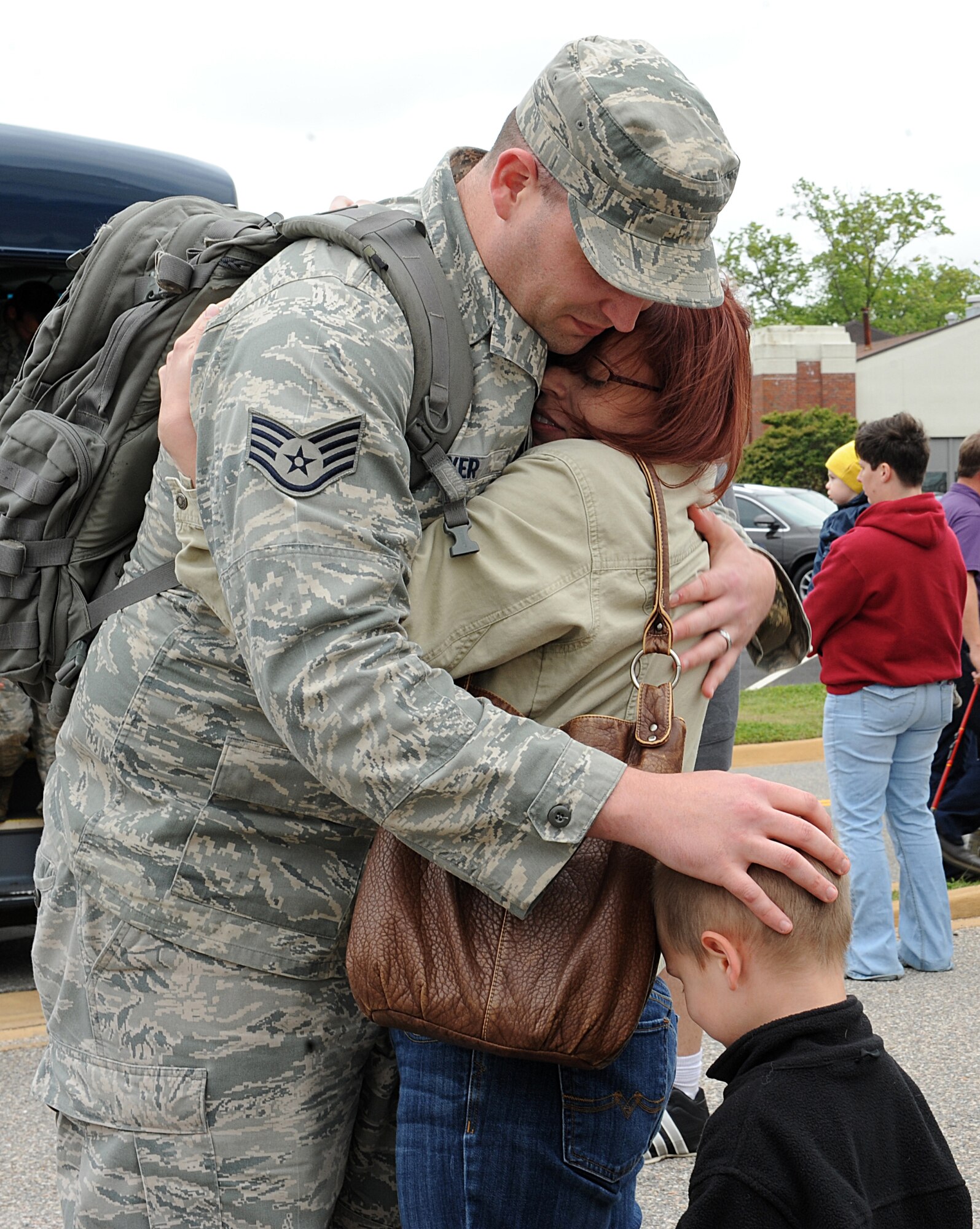 U.S. Air Force Staff Sgt. Rodney Meyers, 94th Aircraft Management Unit weapons load crew team chief, embraces his wife and son at Langley Air Force Base, Va., after returning from a deployment to Kadena Air Base, Japan May 4, 2013. The unit deployed as part of the Pacific Command's Theater Security Package rotation. (U.S. Air Force photo by Airman 1st Class Kimberly Nagle/Released)