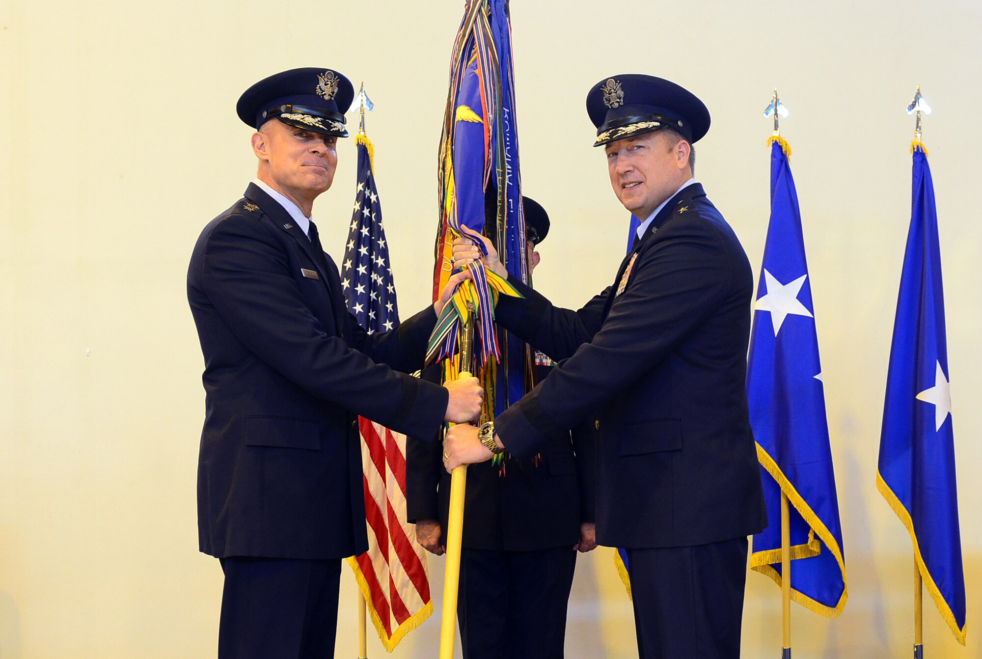 Lt. Gen. Craig A. Franklin, 3rd Air Force commander, passes the 31st Fighter Wing guidon to Brig. Gen. Jon A. Norman during a change of command ceremony May 30, 2013, at Aviano Air Base, Italy. Nearly 1,000 people attended the ceremony held in Hangar 3 and the audience included Airmen, Soldiers, Italian air force members and local community leaders. (U.S. Air Force photo/Airman 1st Class Matthew Lotz)