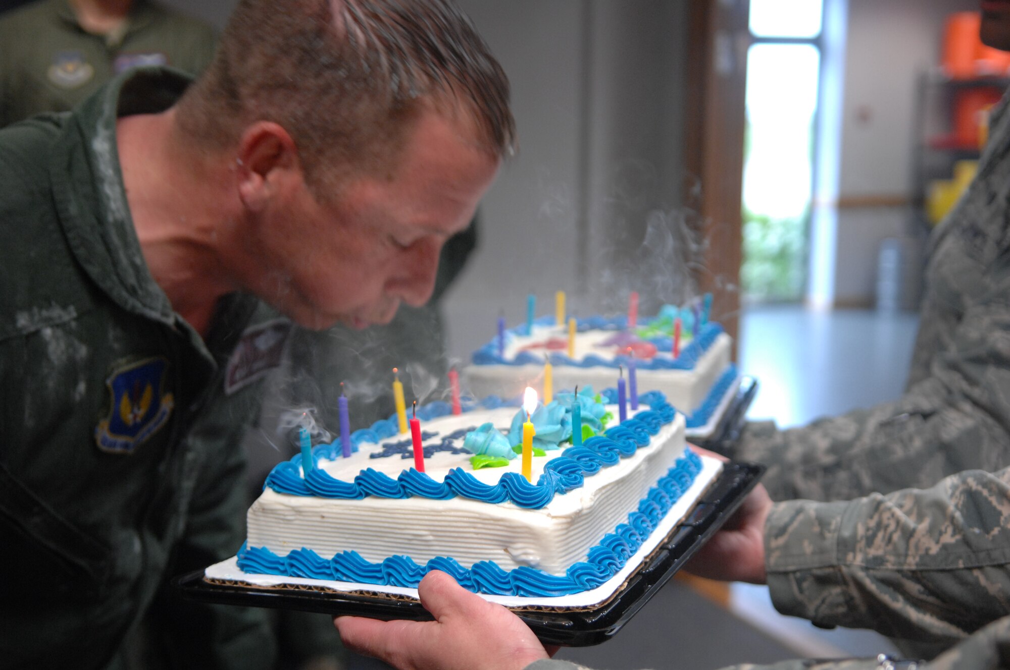 Col. Kyle Voigt, 100th Air Refueling Wing vice commander, blows out candles on cakes May 29, 2013, following his fini flight at RAF Mildenhall, England. Voigt had two cakes - one for his fini flight and one for his birthday, which was the same day. The flight, a routine training refueling mission with the 31st Fighter Wing, commemorated Voigt’s time at RAF Mildenhall.   (U.S. Air Force photo by Airman 1st Class Dillon Johnston/Released)
