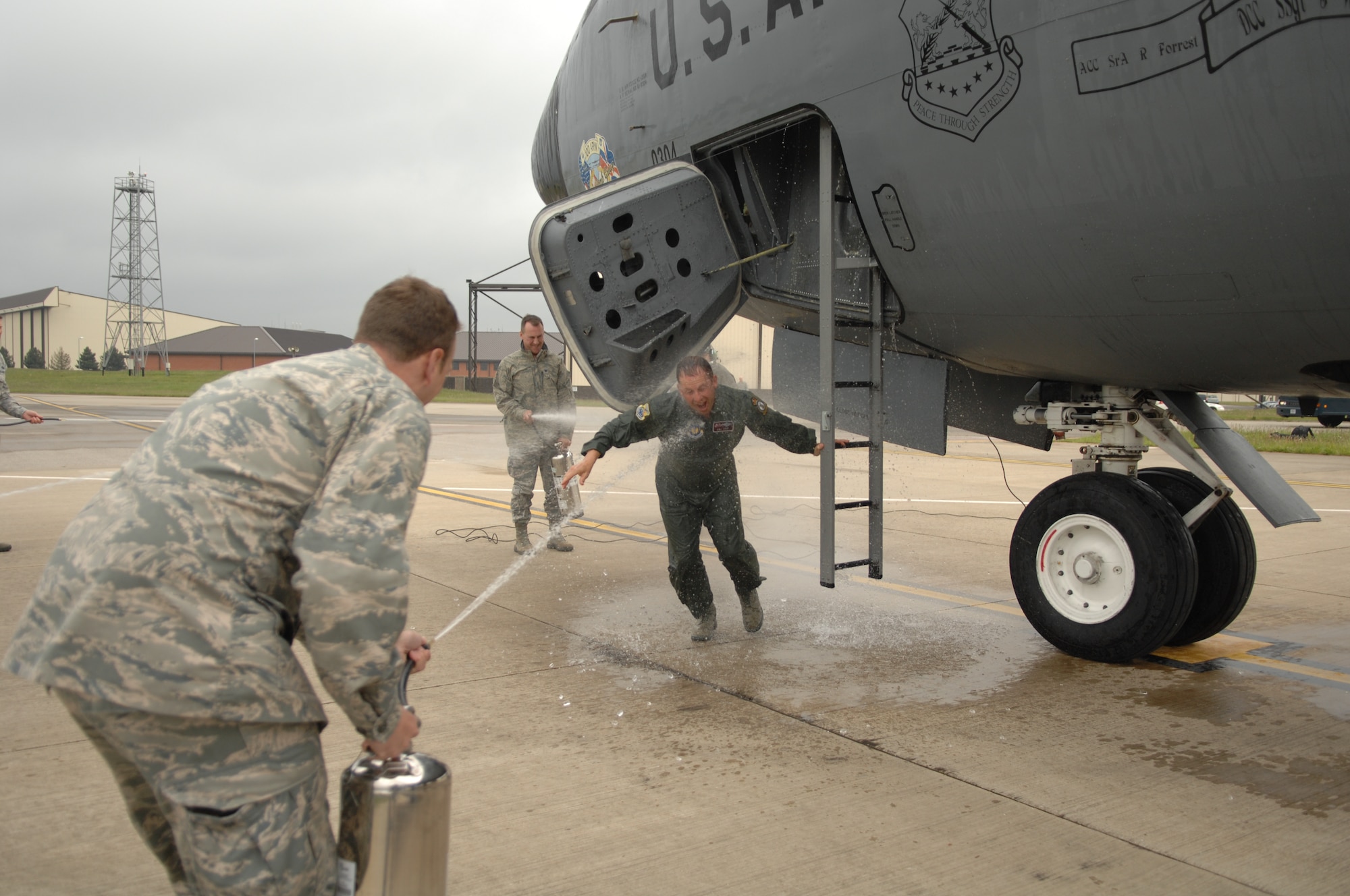 Team Mildenhall members douse Col. Kyle Voigt, 100th Air Refueling Wing vice commander, with water following his fini flight May 29, 2013, at RAF Mildenhall, England. It is tradition to spray both the aircraft and the aircrew member for their fini flight. The flight, a routine training refueling mission with the 31st Fighter Wing, commemorated Voigt’s time at RAF Mildenhall.   (U.S. Air Force photo by Airman 1st Class Dillon Johnston/Released)