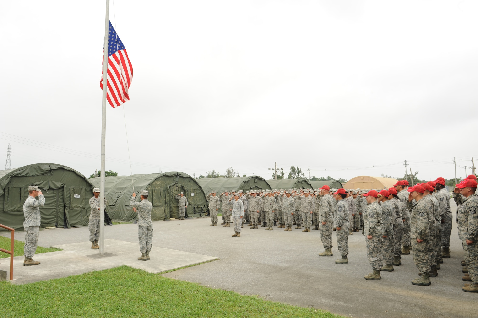 Members of 554th RED HORSE Squadron Detachment 1, and graduates of the final Silver Flag class on Kadena, salute the American flag on Kadena Air Base, Japan, May 22, 2013. Squadron members took part in the final ceremony for the Silver Flag contingency exercise held on Kadena. The exercise is moving to Guam, where its parent unit is located. (U.S. Air Force photo by Airman 1st Class Keith A. James/Released)