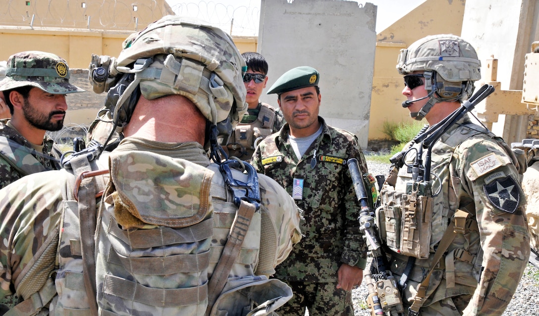 U.S. Army 1st Lt. Chase S. Burnett, right, speaks with Afghan army engineers while assisting in the transfer of training equipment at an Afghan army checkpoint in the Panjwai district of Afghanistan's Kandahar province, May 22, 2013. Burnett, a platoon leader, is assigned to 2nd Infantry Division's 2nd Battalion, 23rd Infantry Regiment.