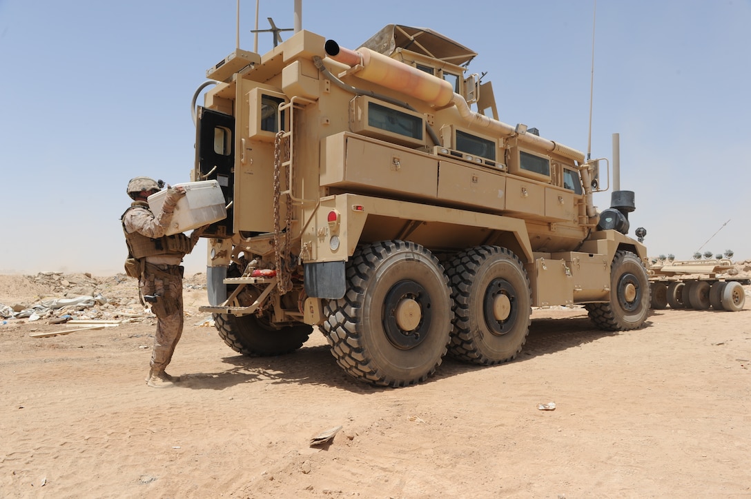 U.S. Navy Petty Officer Corey Badder loads up a mine-resistant, ambush ...