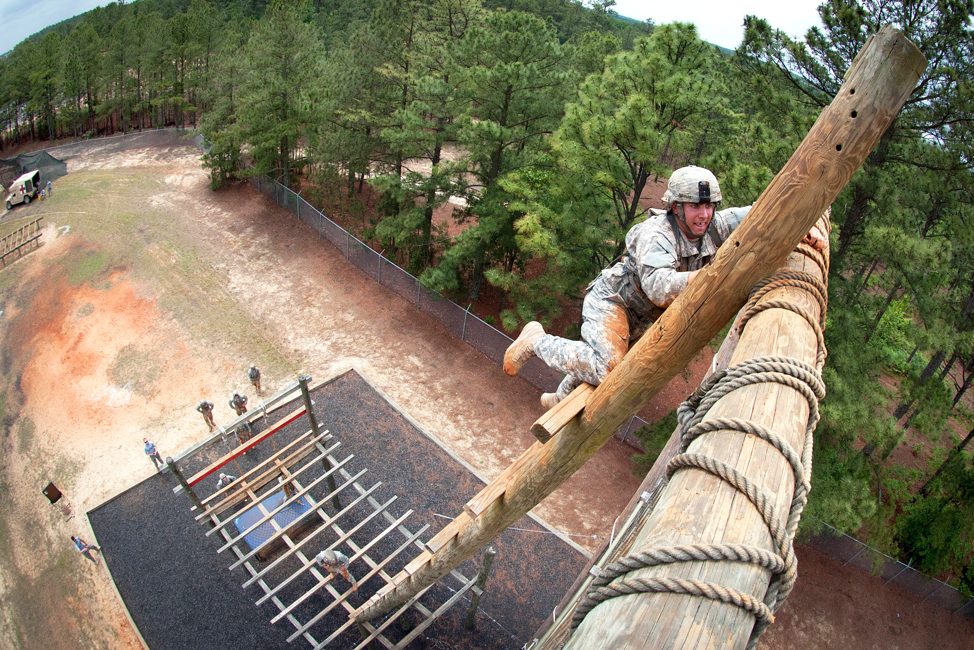 Army Spc. Gannon Kessler climbs a tower obstacle during a team assault obstacle  course competition that