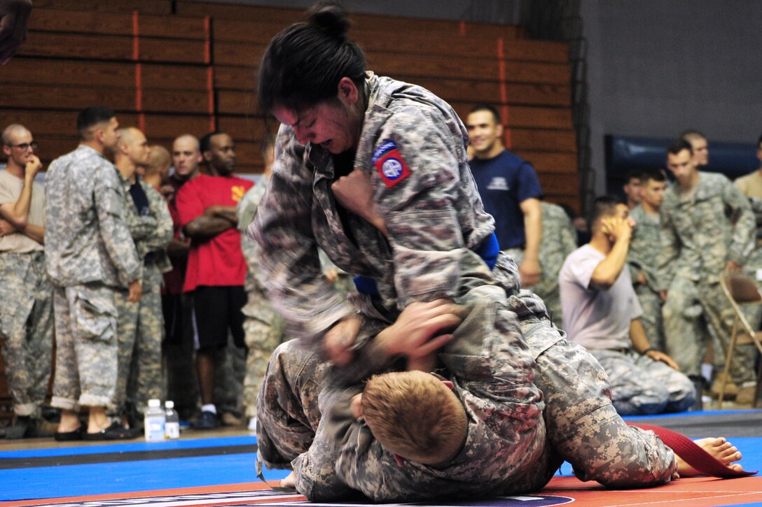 Army Spc. Tania Calderon-Griek, top, gains advantage over Army Sgt. Joshua J. Wright, bottom, during the 82nd Airborne Division's all-American week Combatives Tournament on Fort Bragg, N.C., May 21, 2013. Calderon-Griek is assigned to the 82nd Division's Headquarters Battalion, and Wright, a fire support noncommissioned officer, is assigned to the 82nd Division's Target Acquisition Battery, 327 Field Artillery Battalion, 18th Fires Brigade, Airborne. Calderon-Griek became the first female to enter the final round in the tournament's history. 