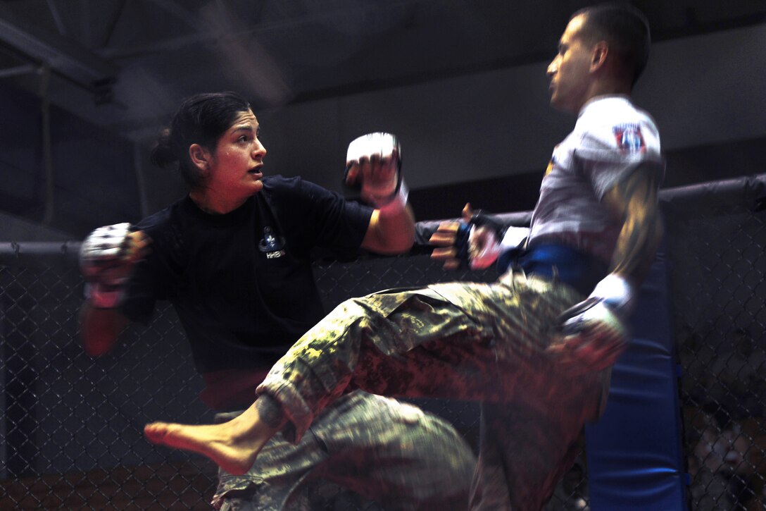Army Spc. Tania Calderon-Griek, left, and Army Sgt. Alberto Nunez Jr., right, move for a dominant position as they compete for the first-place position in the 125-pound weight class during the 82nd Airborne Division's all-American week Combatives Tournament on Fort Bragg, N.C., May 23, 2013. Calderon-Griek is assigned to the 82nd Division's Headquarters Battalion. Nunez is assigned to the 82nd Division's 1st Brigade Special Troops Battalion. Calderon-Griek became the first female to enter the final round in the tournament's history. 